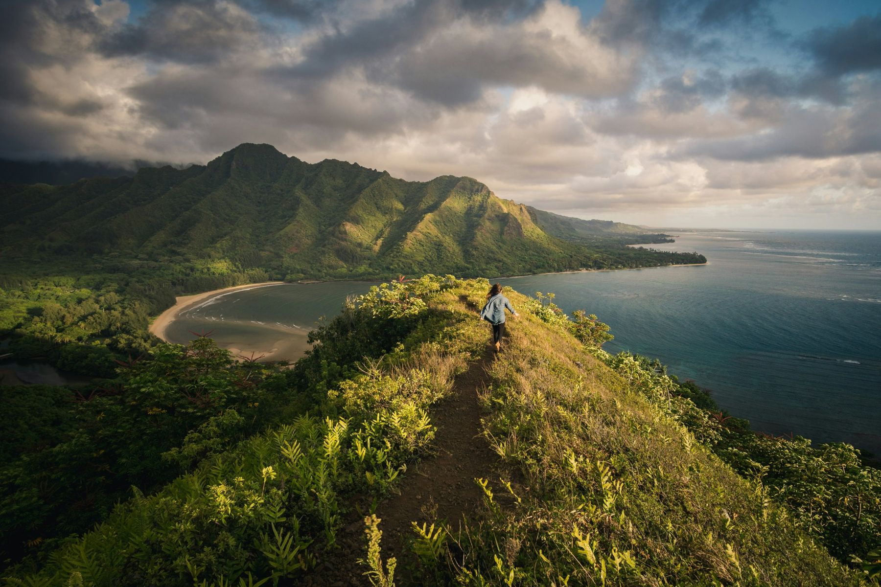 Hiker on a ridge above Kahana Bay and the Koolau mountains